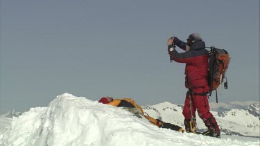 Aerial of Mount Everest: Climber laying down while other is taking a photo or video of mount everest then leaves