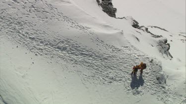 Aerial of Mount Everest: Two climber holding and supporting other climber while walking down.