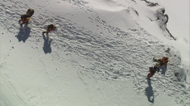 Aerial of Mount Everest:  Other climbers leaving. While others help up troubled climber and begin to walk.