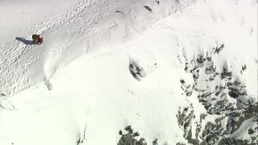 Aerial of Mount Everest: Two climber holding and supporting other climber while walking.