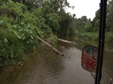 Sumatra forest four-wheel drive 4x4 driving along in river in forest. Point of view
