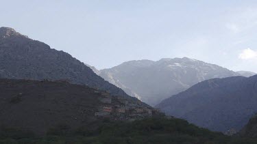 Time lapse of clouds around the Toubkal mountain, Morocco. Day to night. Fades to darkness black