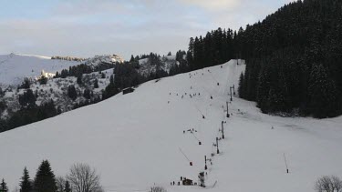 Time lapse of people skiing down a mountain af dusk in the French alpine village of Notre Dame de Bellecombe