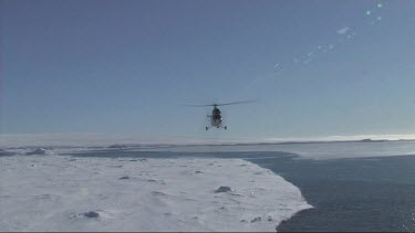 Helicopter landing on the back of an icebreaker in the Weddell Sea, Antarctica