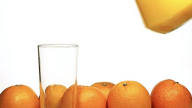 Orange Juice being poured into Glass against White Background, Slow Motion