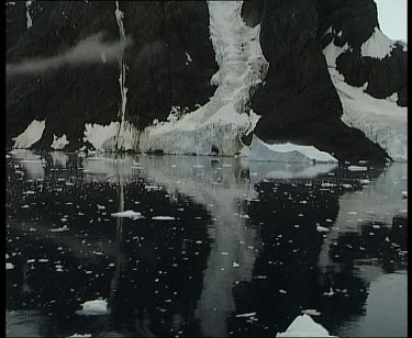 Large monolithic rock mountain with snow "river" in valley