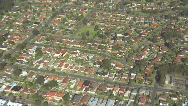 Very high shot of Suburbia, houses, regular straight lines of roads and houses and parks.