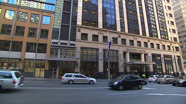 Exterior shot WS Australian Securities Exchange Stock Exchange ASX.  Exchange Square with Sydney buses and cars driving past. 18 Bridge Street Sydney.