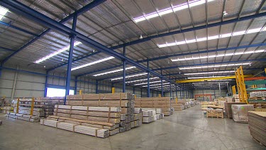 Long shot building construction supplies in a warehouse or factory.