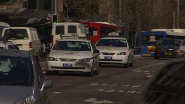 Taxi cabs and cars and delivery vans, streets of central Sydney.