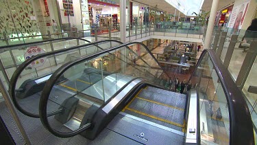 Shopping Centre mall with two women riding up escalator