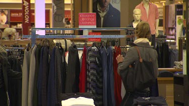 Two women looking at fashion clothes on sale