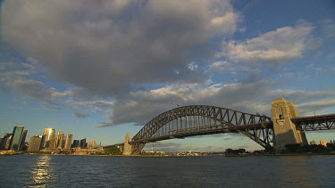 Sydney harbour with Harbour bridge and North Sydney, Millers Point, Kirribilli. Gentle soft light with clouds. Ferry passes under bridge