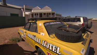 Scale model of Birdsville Hotel on top of yellow cab (taxi).