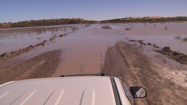 Point of View four wheel drive car driving over flooded roads -  Simpson Desert Diamantina River