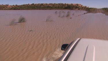 Point of View four wheel drive car driving over flooded roads -  Simpson Desert Diamantina River