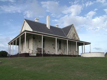 Cape Otway lighthouse building. Old building with paint peeling, white-washed.