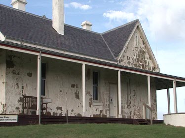 Cape Otway lighthouse building. Old building with paint peeling, white-washed.