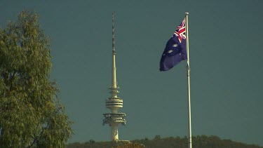 Canberra. Communications tower Black Mountain Tower. Formerly called Telstra Tower. With Australian flag in foreground blowing in the wind.