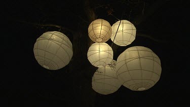 White round Chinese lanterns with lights inside.