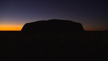 Sunset wide shot Uluru in silhouette