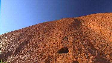 low angle rocks with blue sky above. Uluru