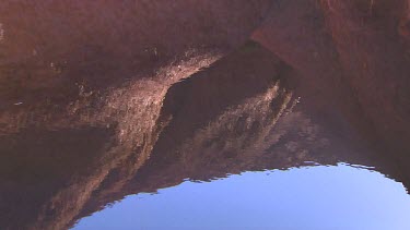 Reflection of rocks in pool of water in desert Uluru