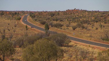 Cars and road trucks on desert road, central desert, Australia