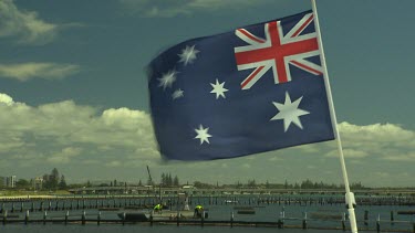 Oyster farming. Two men working on oyster farm, farmers. Australian Flag in foreground.