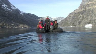 Tourists in rubber dinghy on a remote fjord of Greenland