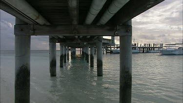 Pier jetty dock. Shot underside of wooden pier supported by wooden piles;