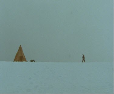 One man camping in snowy white landscape