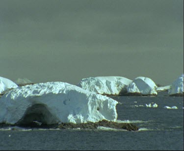 Thick crust of ice on Antarctic coast. Polar coastal landscape.