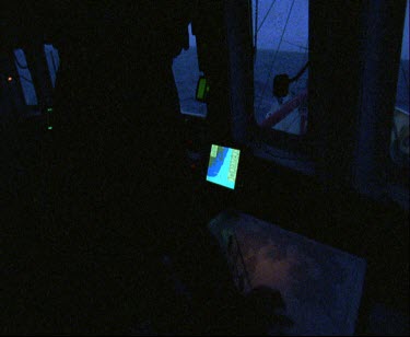 Inside bridge of ship at night. Radar and communication devices.