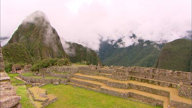 Machu Picchu side on view with a few clouds over the mountains
