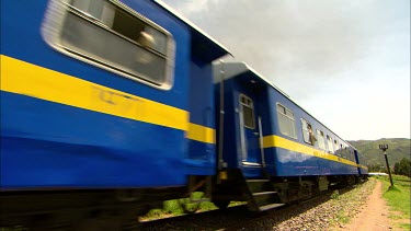 Close up side on shot of blue and yellow Andean Explorer train