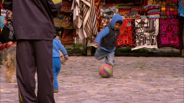 Child playing with a dog at a local market in Ollantaytambo