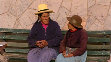 Two older women sitting on a bench in Ollantaytambo
