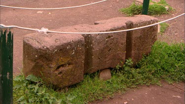 A large block of carved rock from the Inca period, protected by a rope barrier