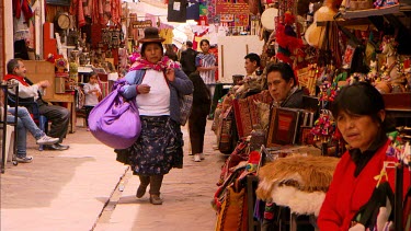 Woman walks down a narrow market alley in Peru