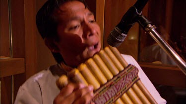 Peruvian musician playing the traditional pipes in a luxury hotel