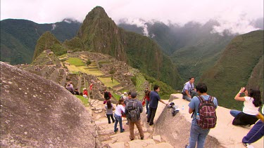 Machu Picchu with clear skies, with a group of tourists taking photos