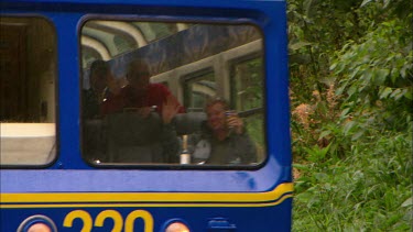 A Vista Dome train passing by with tourists in the front waving