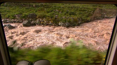 View of rapids in the Urubamba river from a train window. River is very close to the tracks