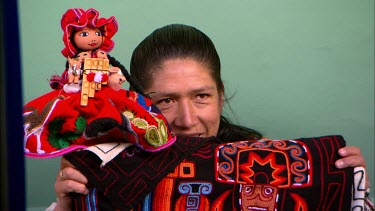 A peruvian woman shows off her puppets and crafts