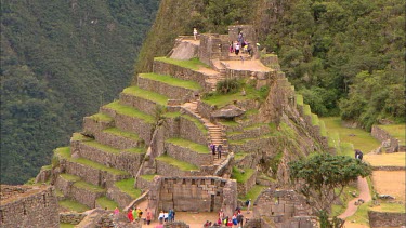 One of the highest parts of Machu Picchu with tourists exploring inside