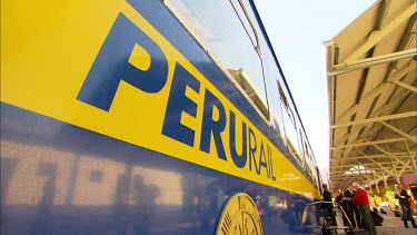 Close up of a blue and yellow Perurail train at a station