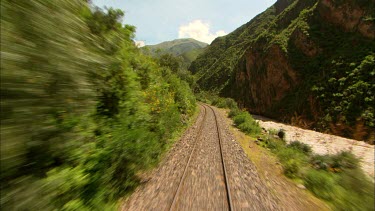 Shot from very back of a train following the rails with the the Urubamba river following the tracks