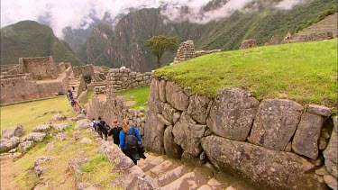 Tourist walking through the rock terraces in Machu Picchu