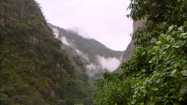 Zooming in up the valley to a cloud covered mountain in Peru